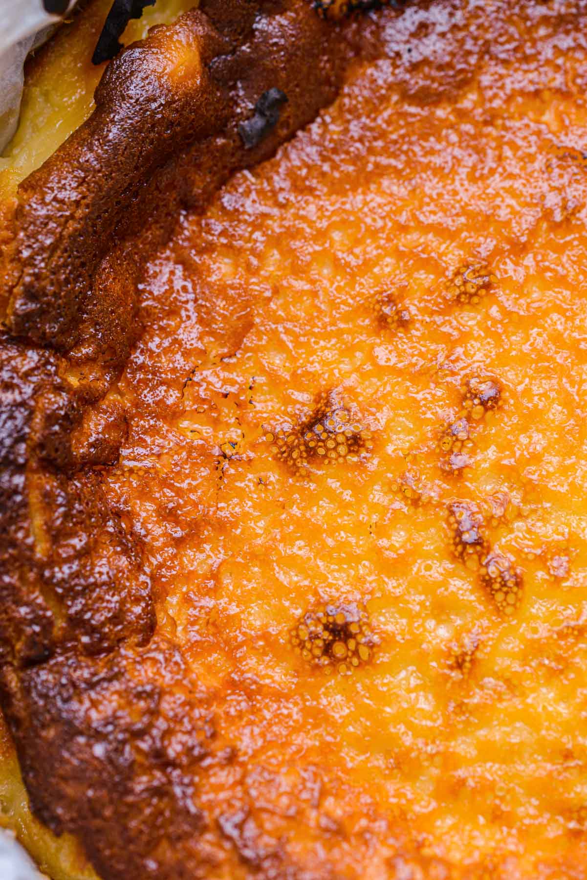 crispy browned top of a cheesecake seen close up.