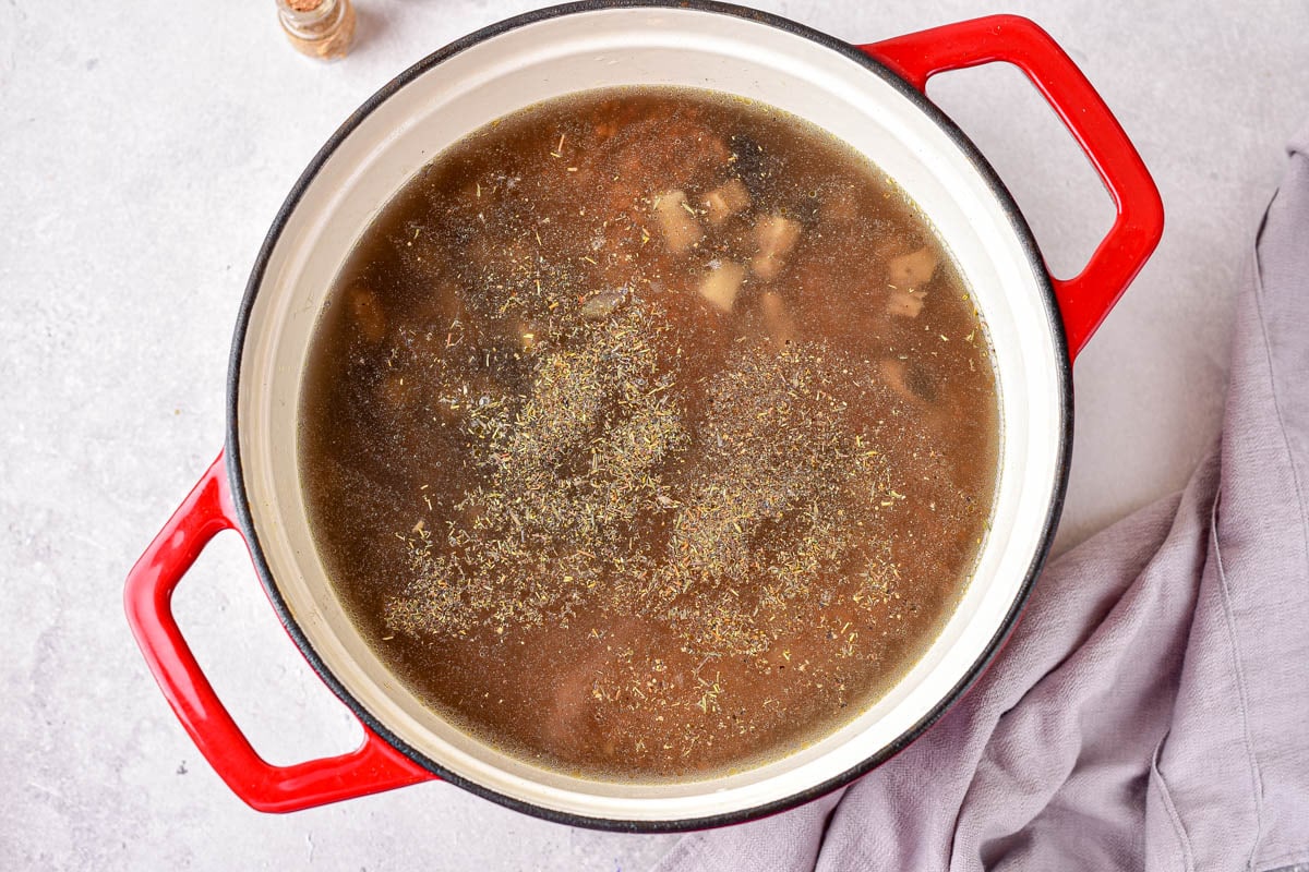 broth in large pan with buckwheat mixture underneath sitting on counter.