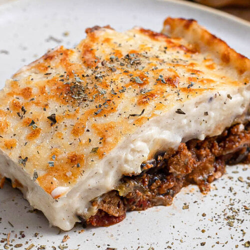 rectangle slice of moussaka on plate with spices.