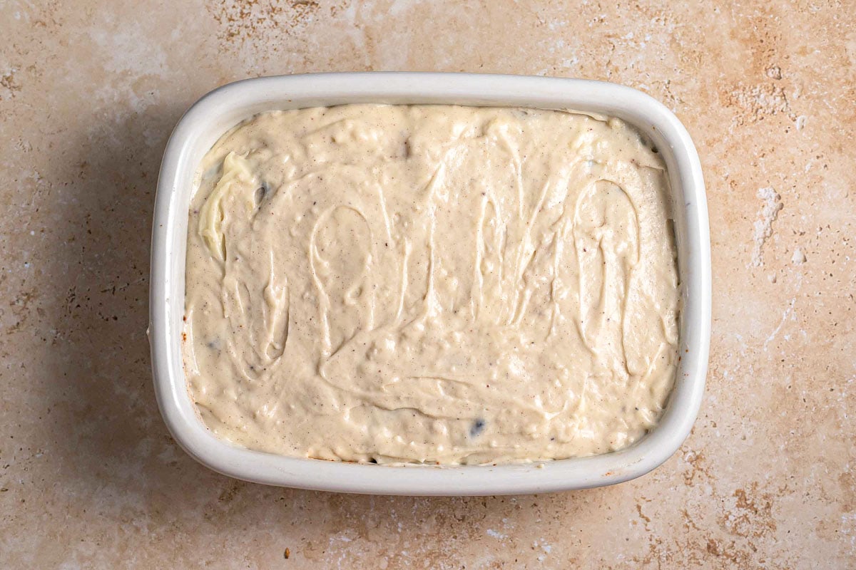 creamy sauce layer spread over rectangle baking dish.