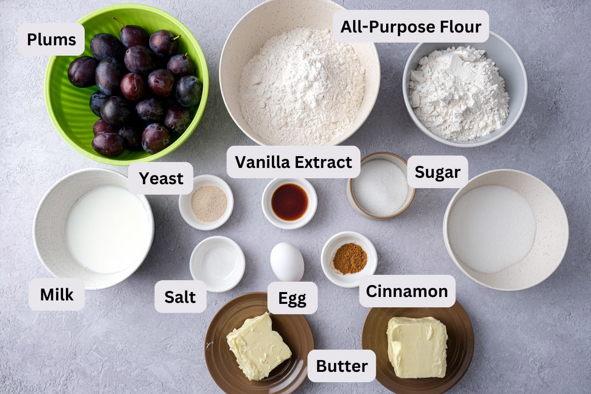 ingredients to make german plum cake on counter in bowls with labels.