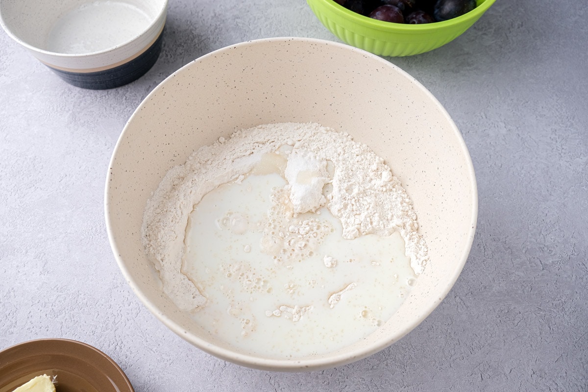 milk and flour sitting in white mixing bowl on counter.