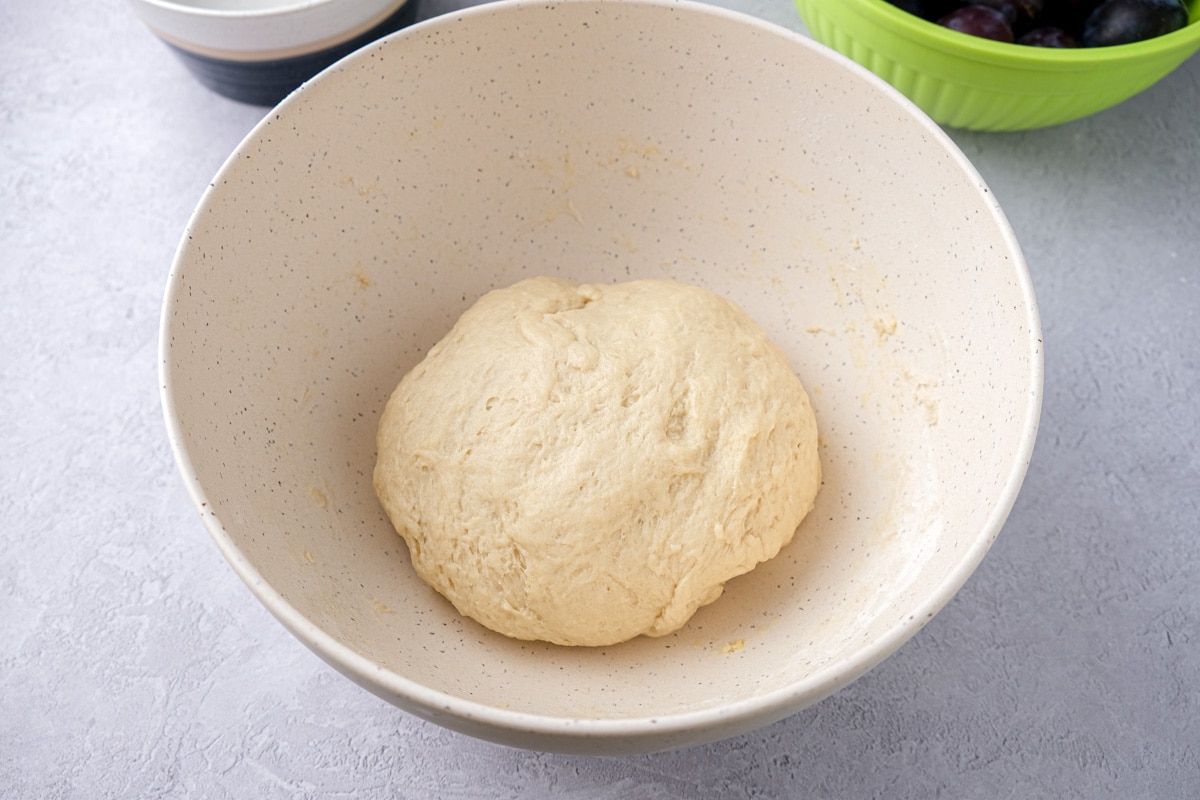 ball of yeast dough in white bowl.