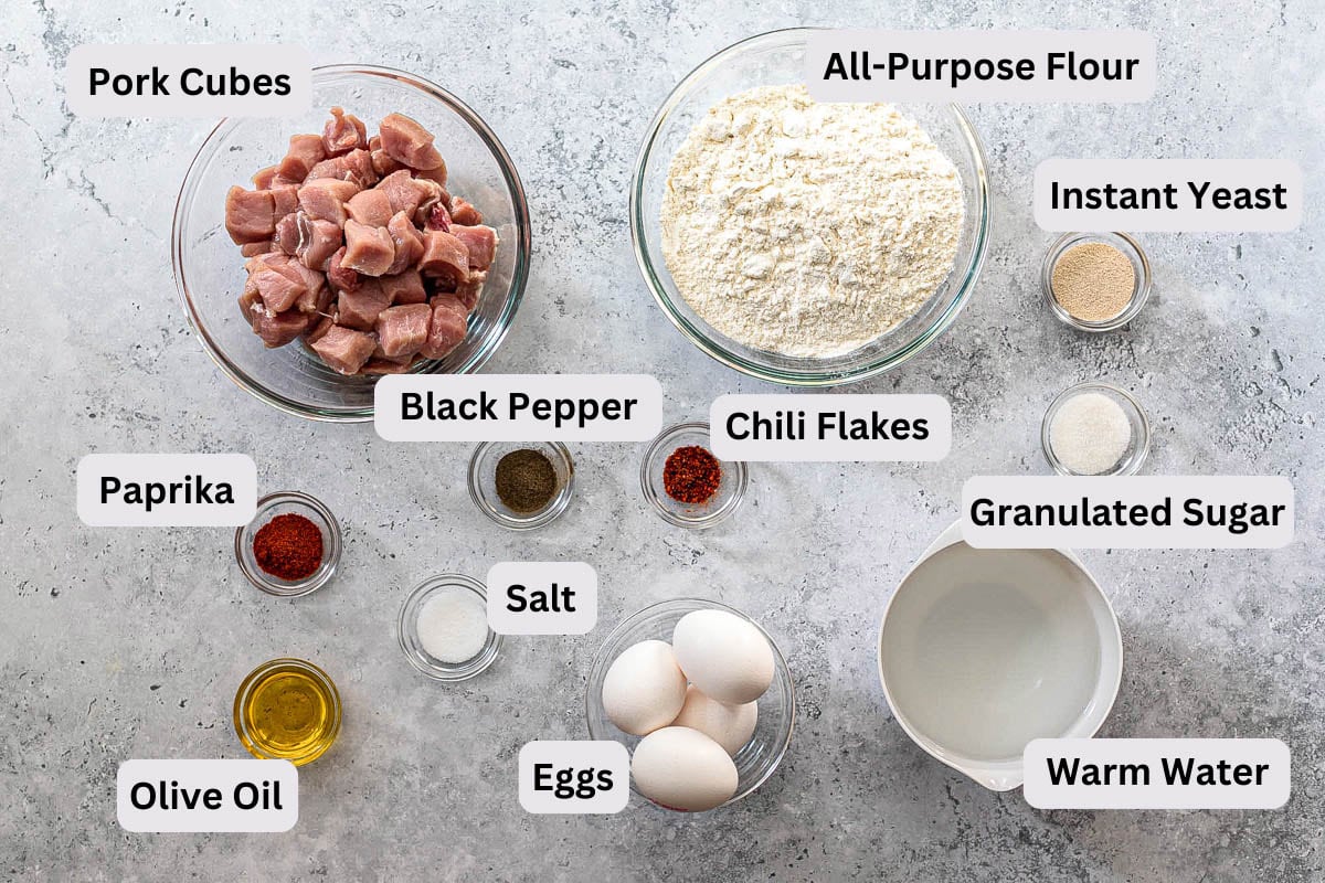 ingredients to make macedonia pizza on counter in bowls with labels.
