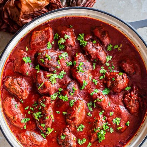 large pot filled with greek meatballs covered in tomato sauce.