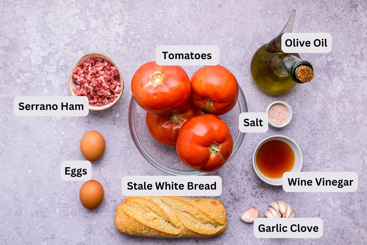 ingredients to make creamy tomato soup on counter in bowls with labels.