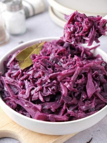 cropped-rotkraut-german-red-cabbage-recipe-new.jpg white bowl of german red cabbage with spoon lifting some out.
