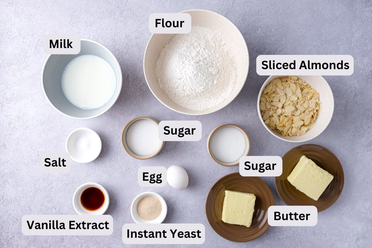 ingredients to make german butter cake in bowls with labels on counter.