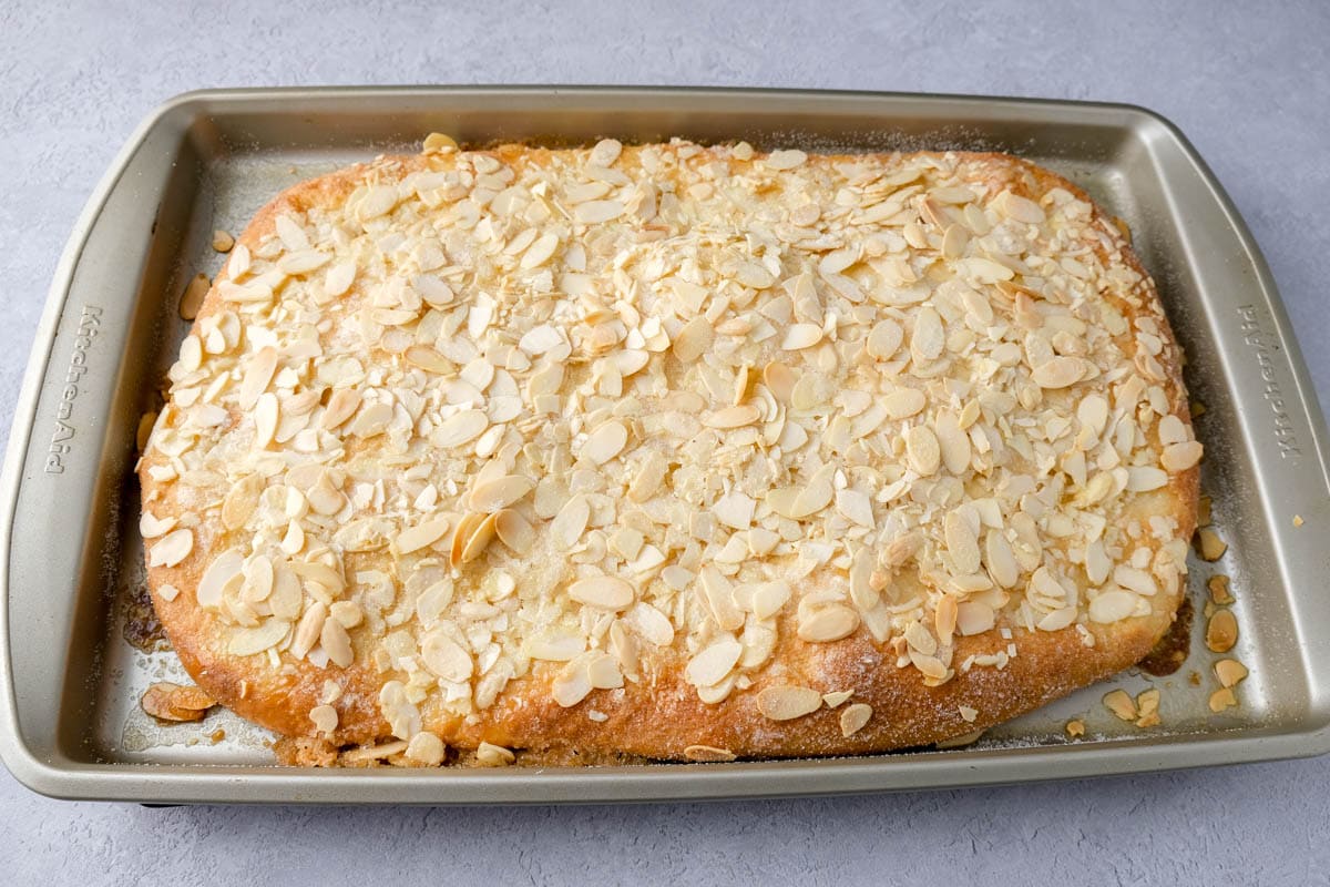 cooked german butter cake in baking sheet sitting on counter.