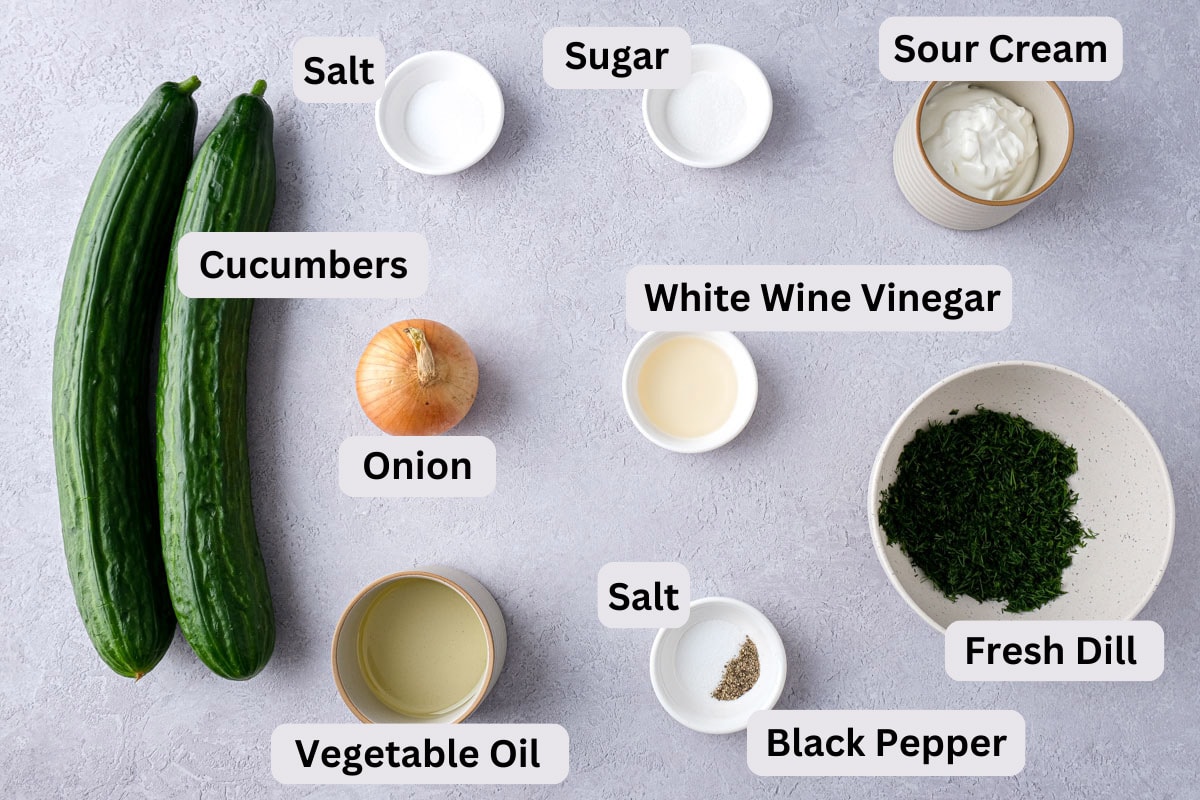 ingredients to make german cucumber salad on counter in bowls with labels.