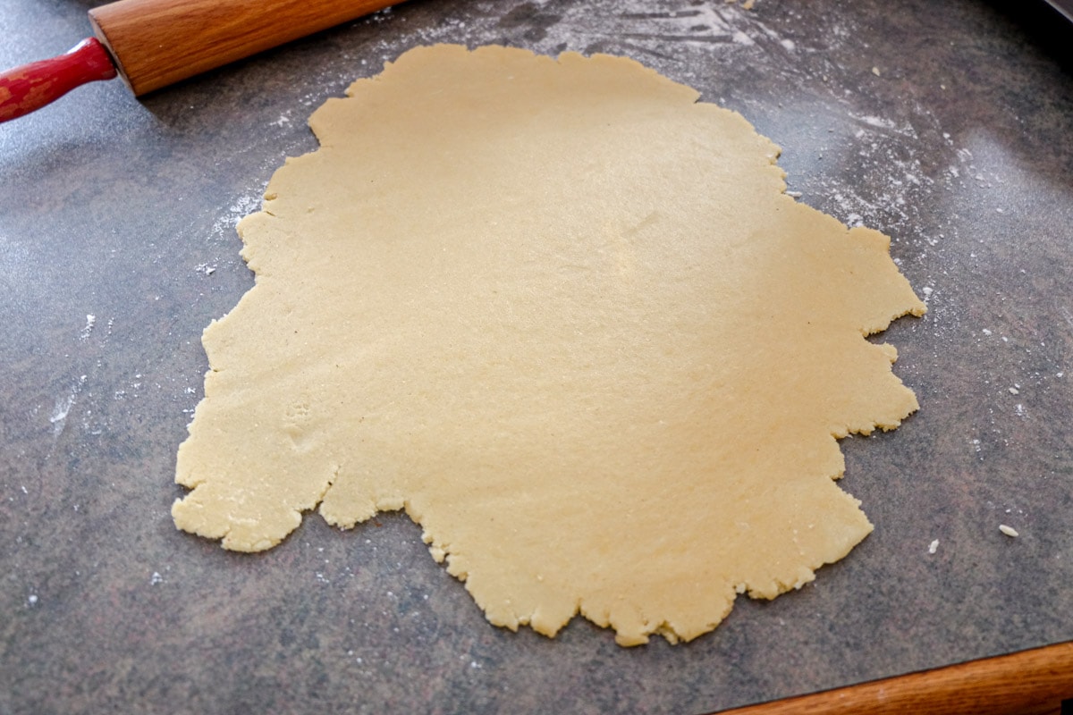 cookie dough rolled out flat on kitchen counter top.