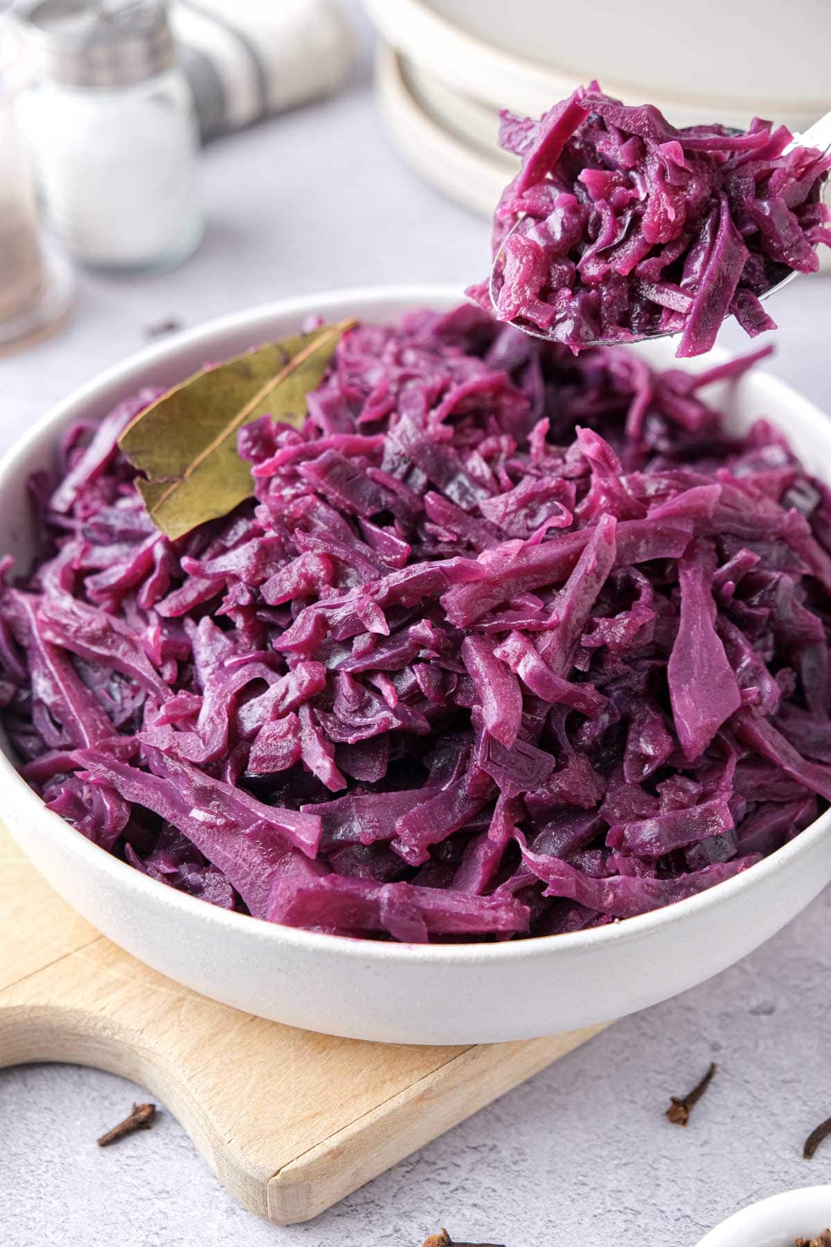 white bowl of german red cabbage with spoon lifting some out.