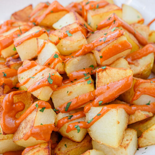 spanish fried potatoes with red sauce in bowl.