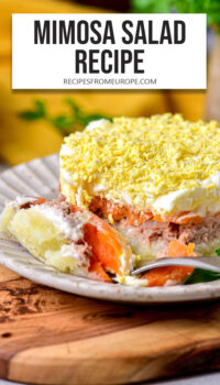 small mimosa salad with different layers on plate and text overlay "Mimosa Salad Recipe".