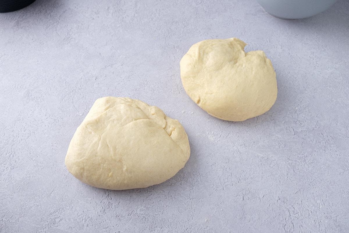 two balls of dough sitting on counter top.