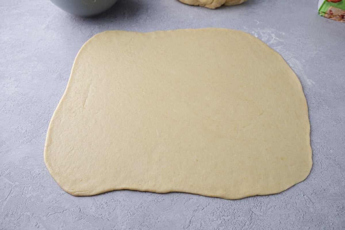 poppy seed roll dough rolled out on a counter top.