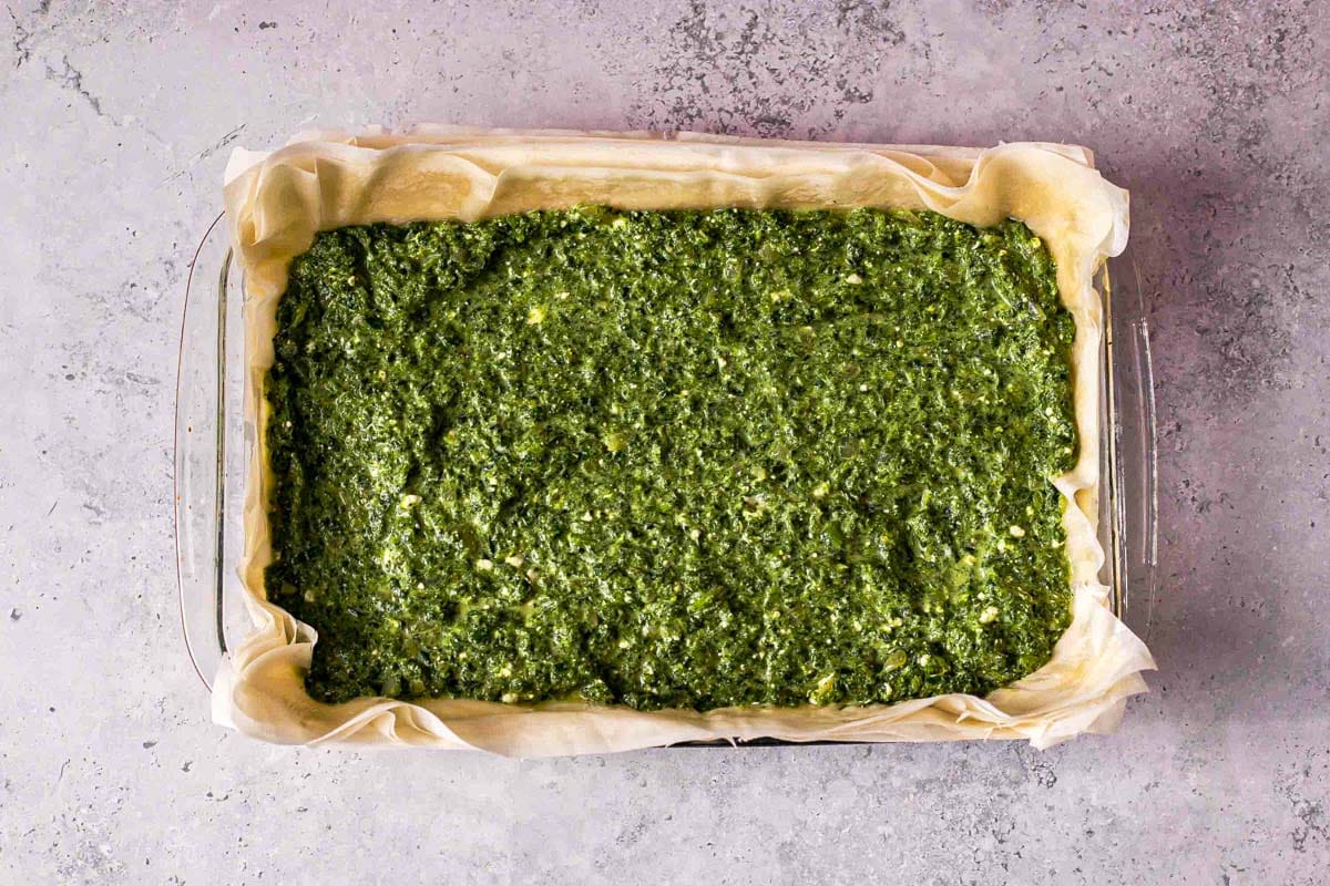 baking dish lined with phyllo dough filled with spinach cheese mixture.