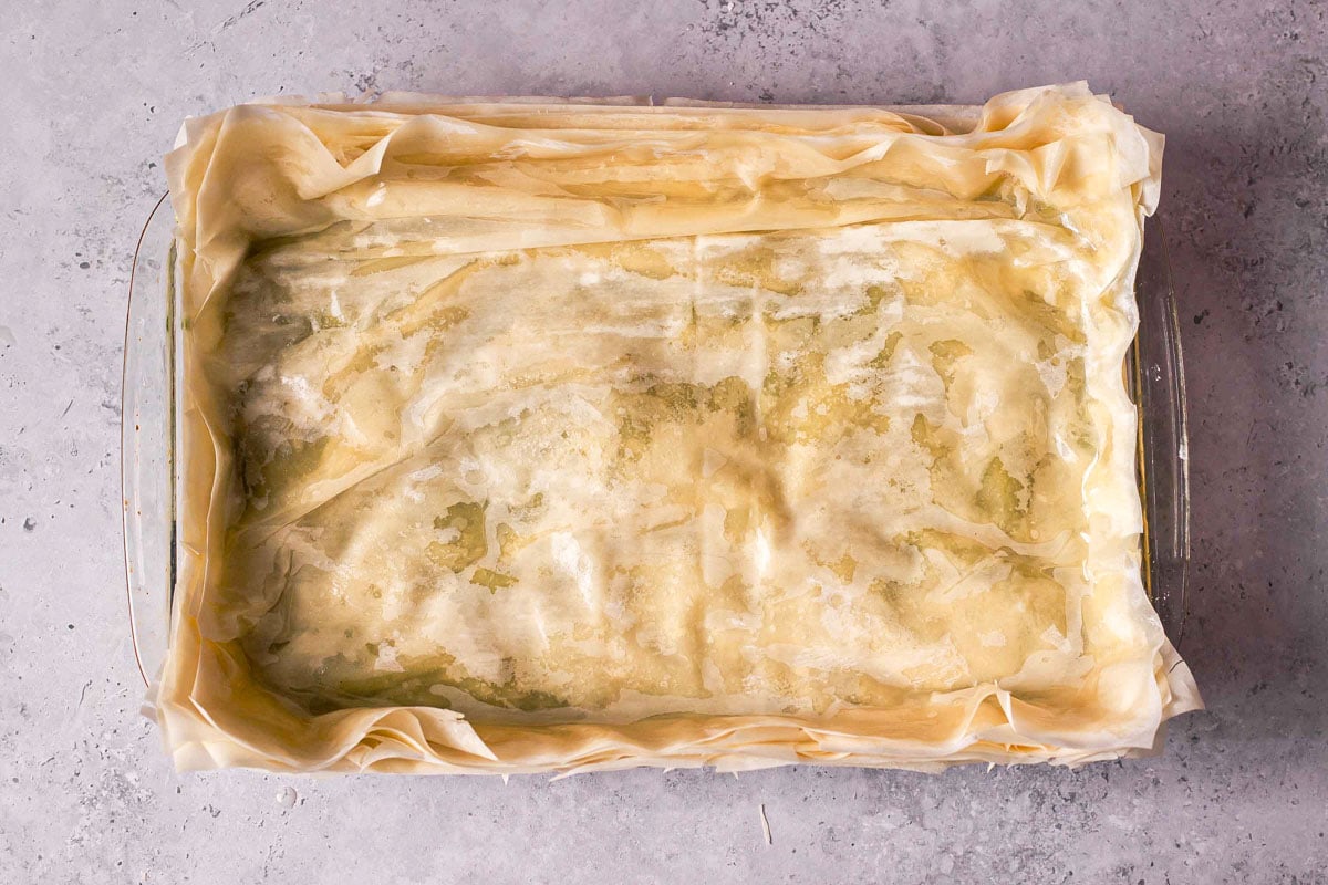 baking dish covered in phyllo dough sheets on top and bottom.