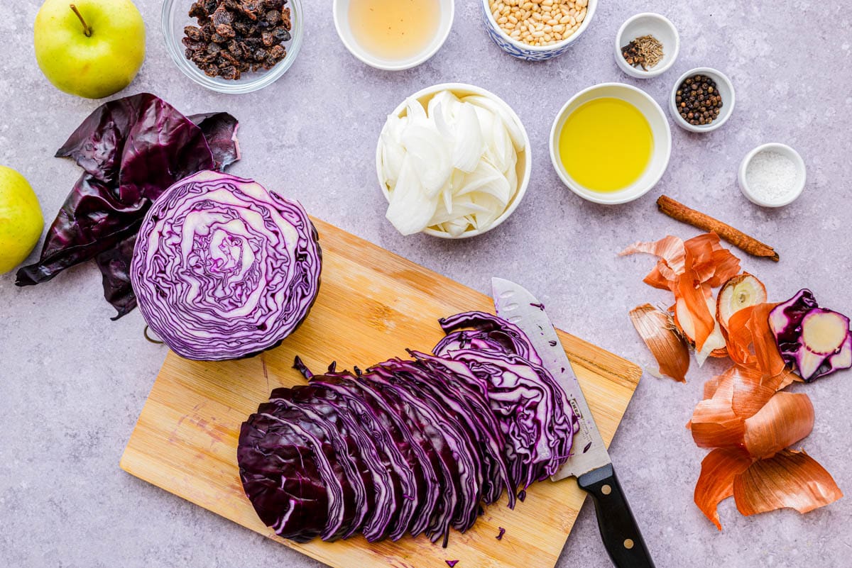 red cabbage cut into thin slices on wooden cutting board.