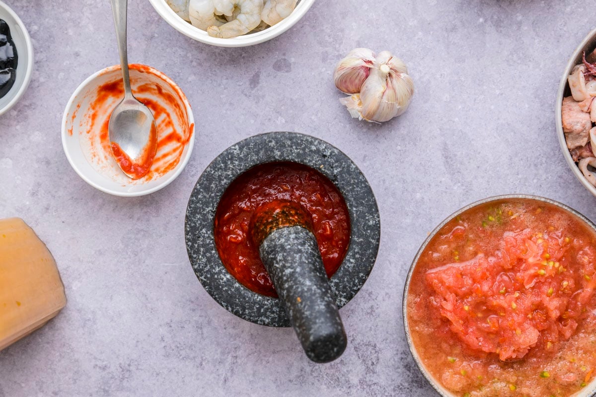 red pepper mixture in mortar and pestle sitting on counter.