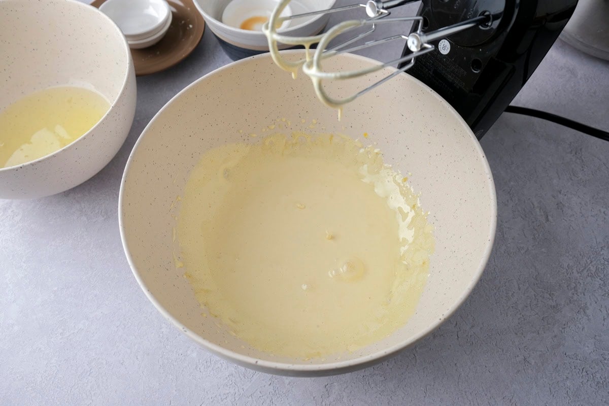 egg yolks and sugar mixture in white mixing bowl on counter.