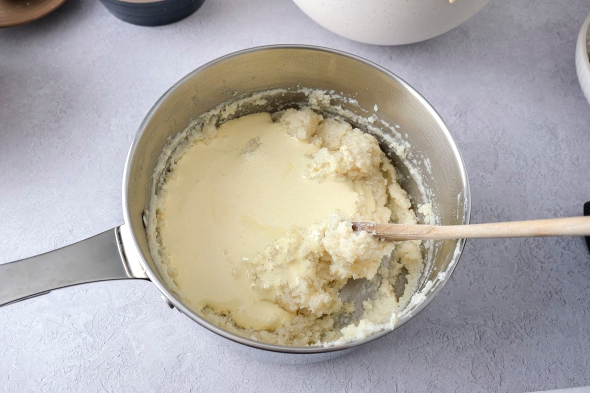 egg yolk mixture folded into semolina mixture in pot.