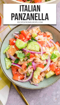 salad with bread, cucumber, tomatoes and other ingredients in bowl and text overlay "Italian Panzanella".