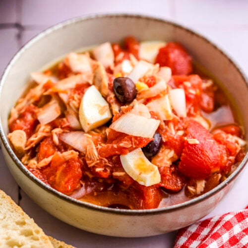 juicy spanish salad with tomatoes are egg in bowl on counter.