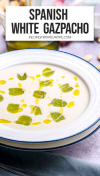 white soup with grapes and oil in bowl and text overlay "Spanish White Gazpacho".
