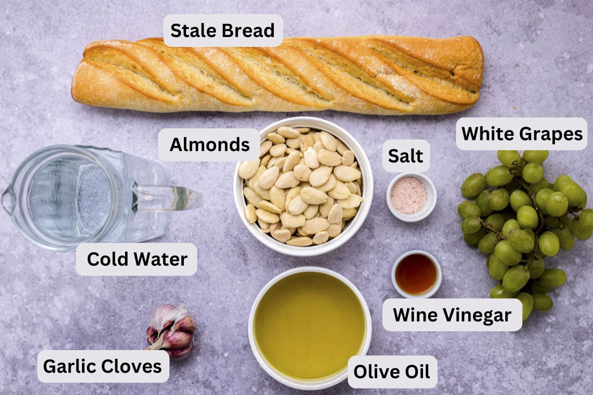 ingredients to make white gazpacho soup on counter in bowls with labels.