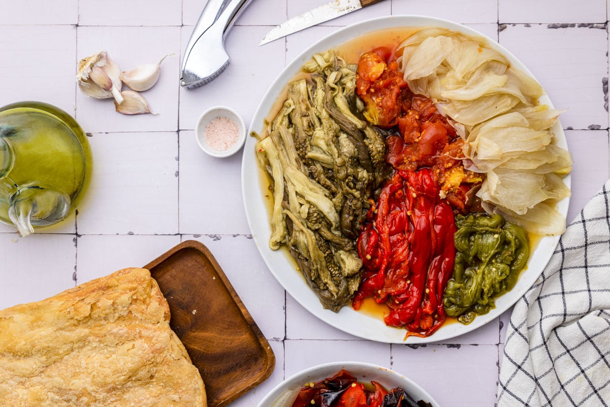 large plate of peeled roasted vegetables on counter.