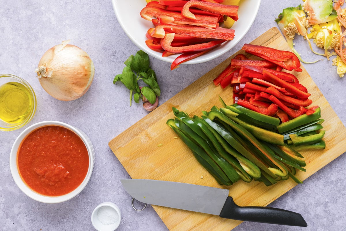 bell peppers cut into slices on wooden cutting board.