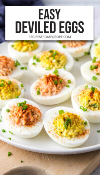deviled eggs with yellow and red filling on plate and chives on top plus text overlay "easy deviled eggs".