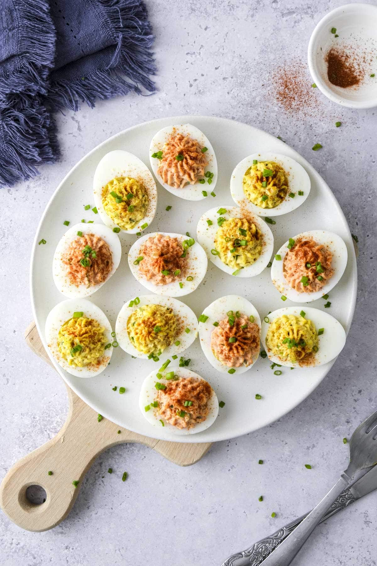 platter of deviled eggs with garnish on them sitting on counter.
