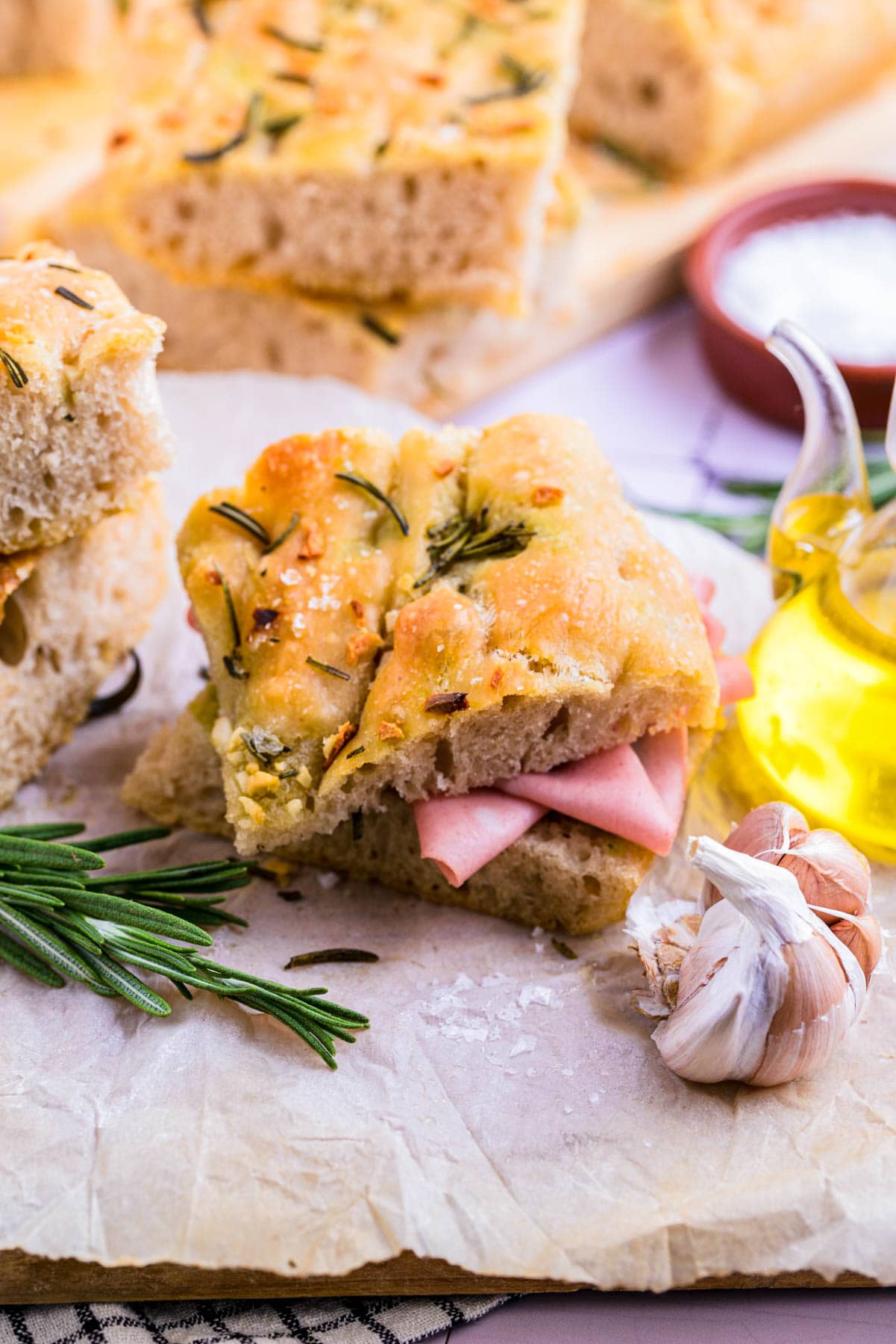 focaccia sliced in half with ham laying in between.