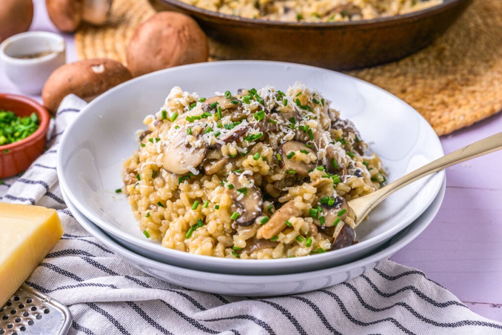 mushroom risotto recipe og-1 bowl of mushroom risotto covered in cheese on counter.