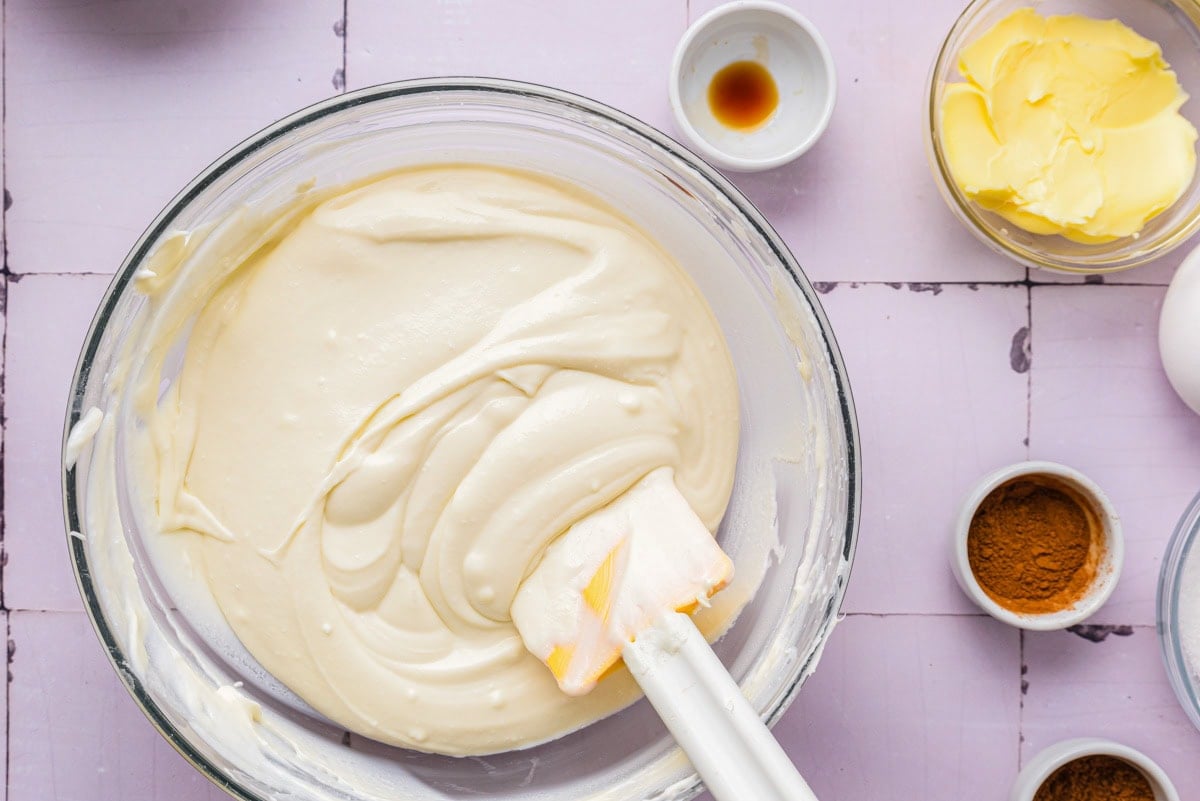 creamy cheese filling in glass bowl with spatula sticking out.