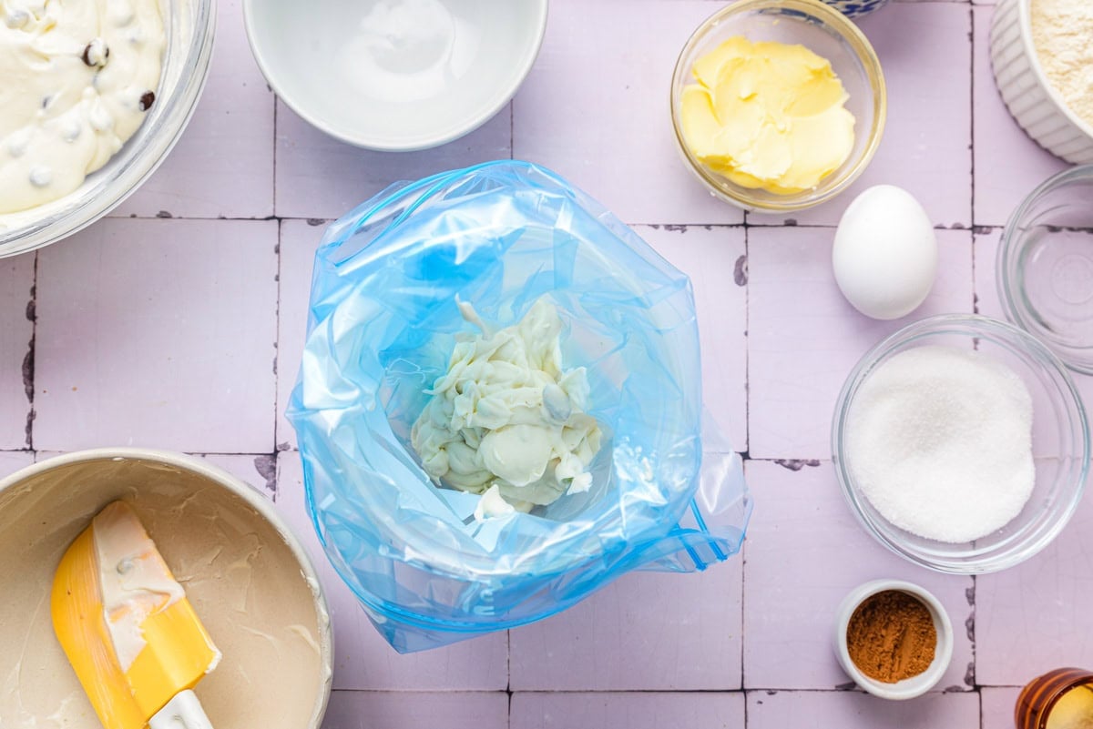 creamy cheese filling in blue piping bag on counter.