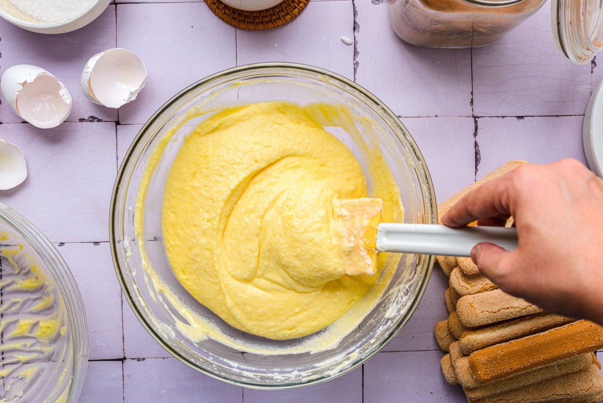 thick sweet cheese mixture in glass bowl mixed with spatula.