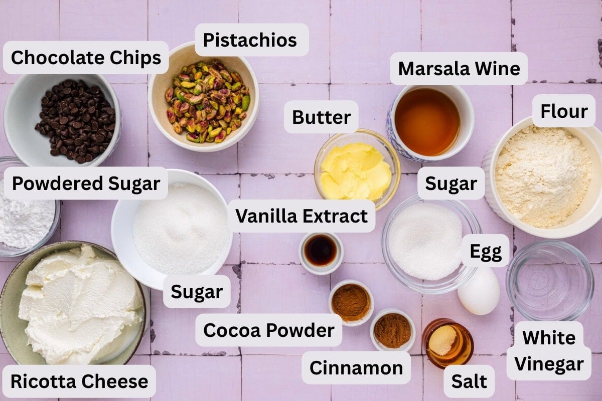 ingredients to make cannoli in bowls on counter with labels.