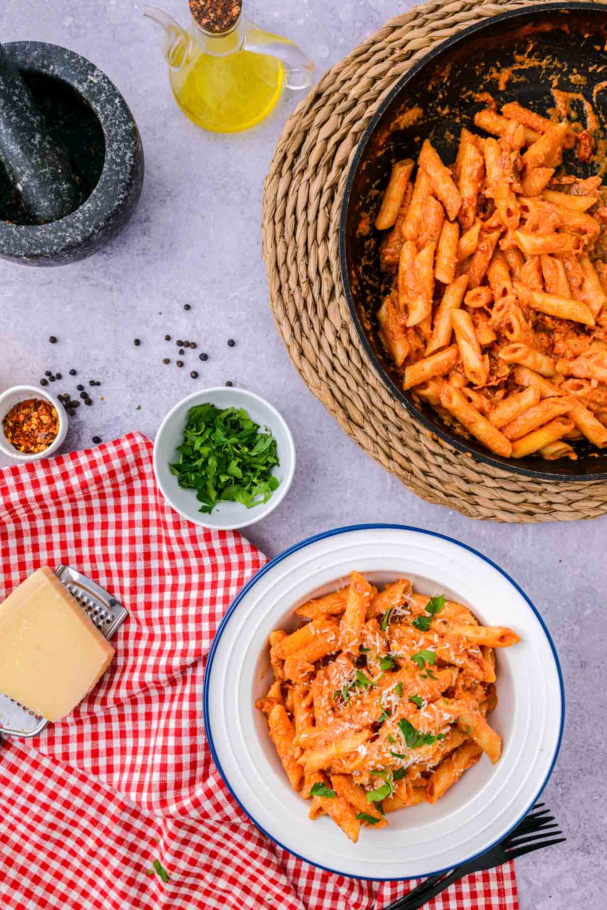 serving of penne alla vodka on counter with sauce pan of pasta behind.