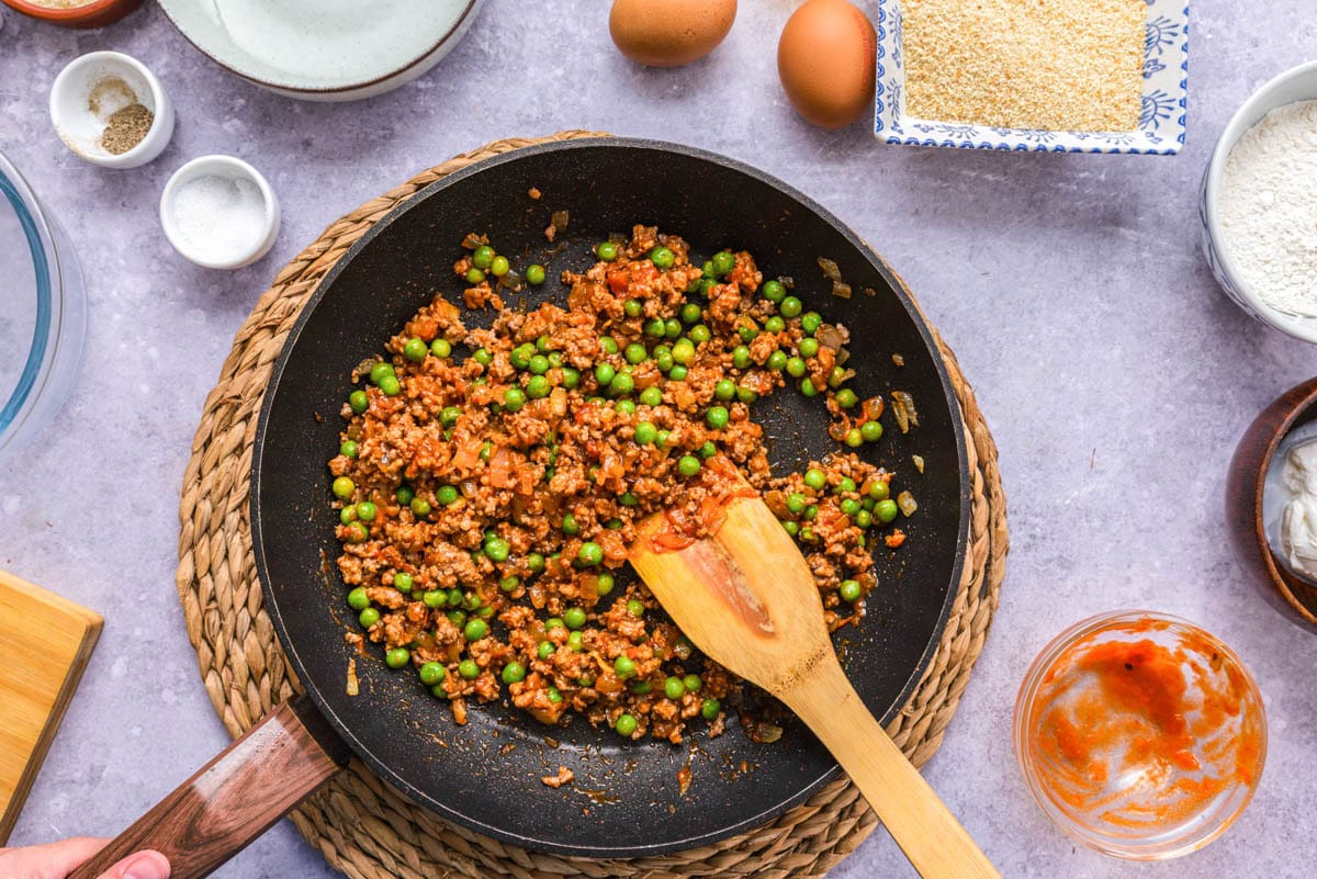 meat ragu sauce in black frying pan on counter.