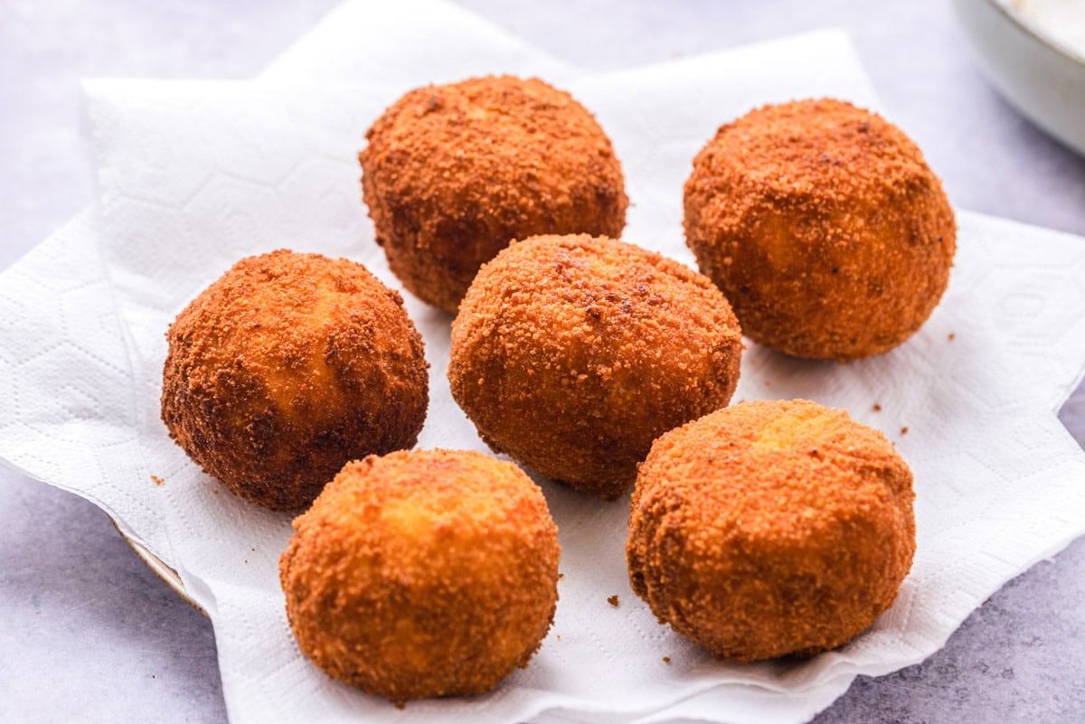 fried italian rice balls on paper towel covered plate.