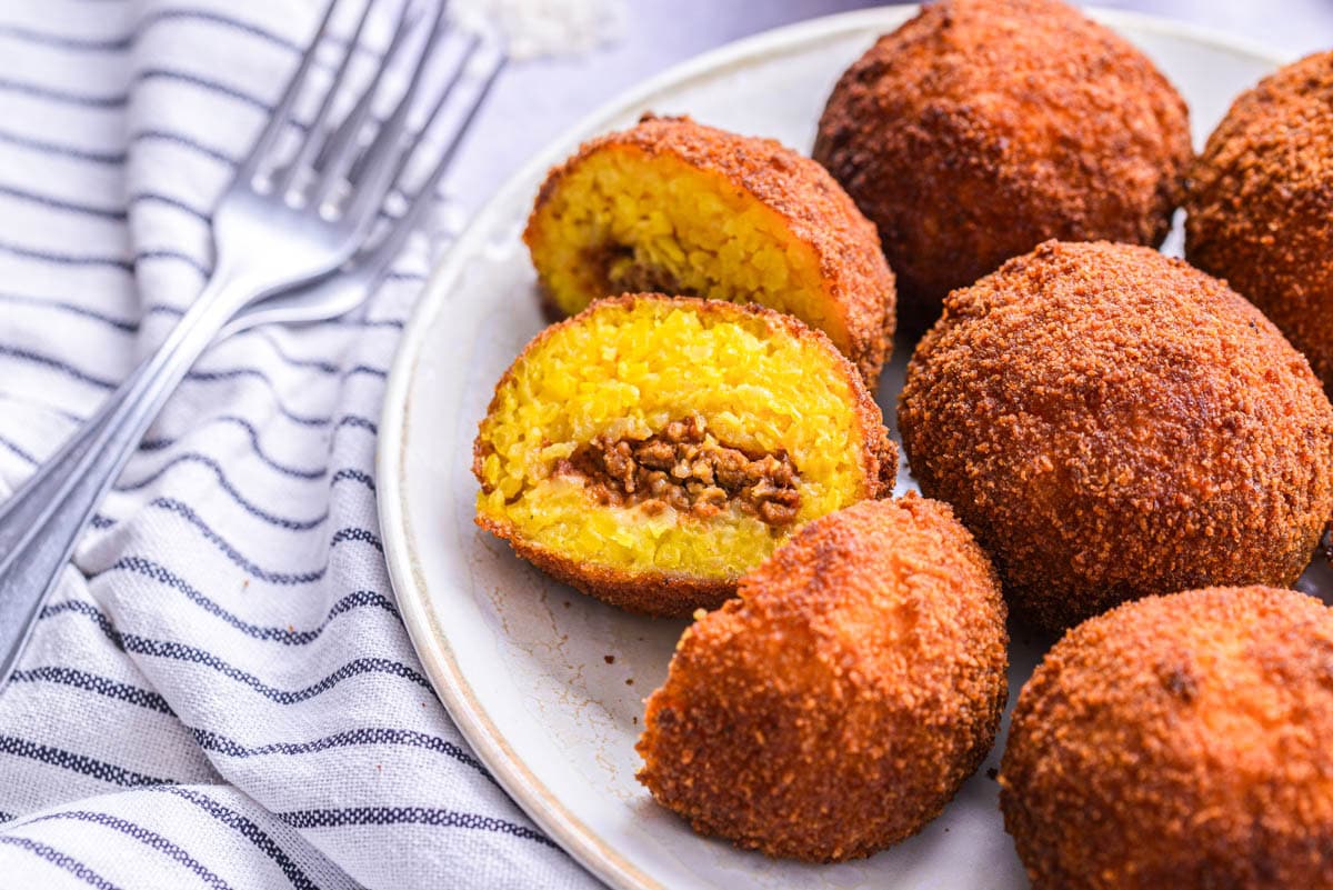 italian arancini rice balls cut in half on plate.