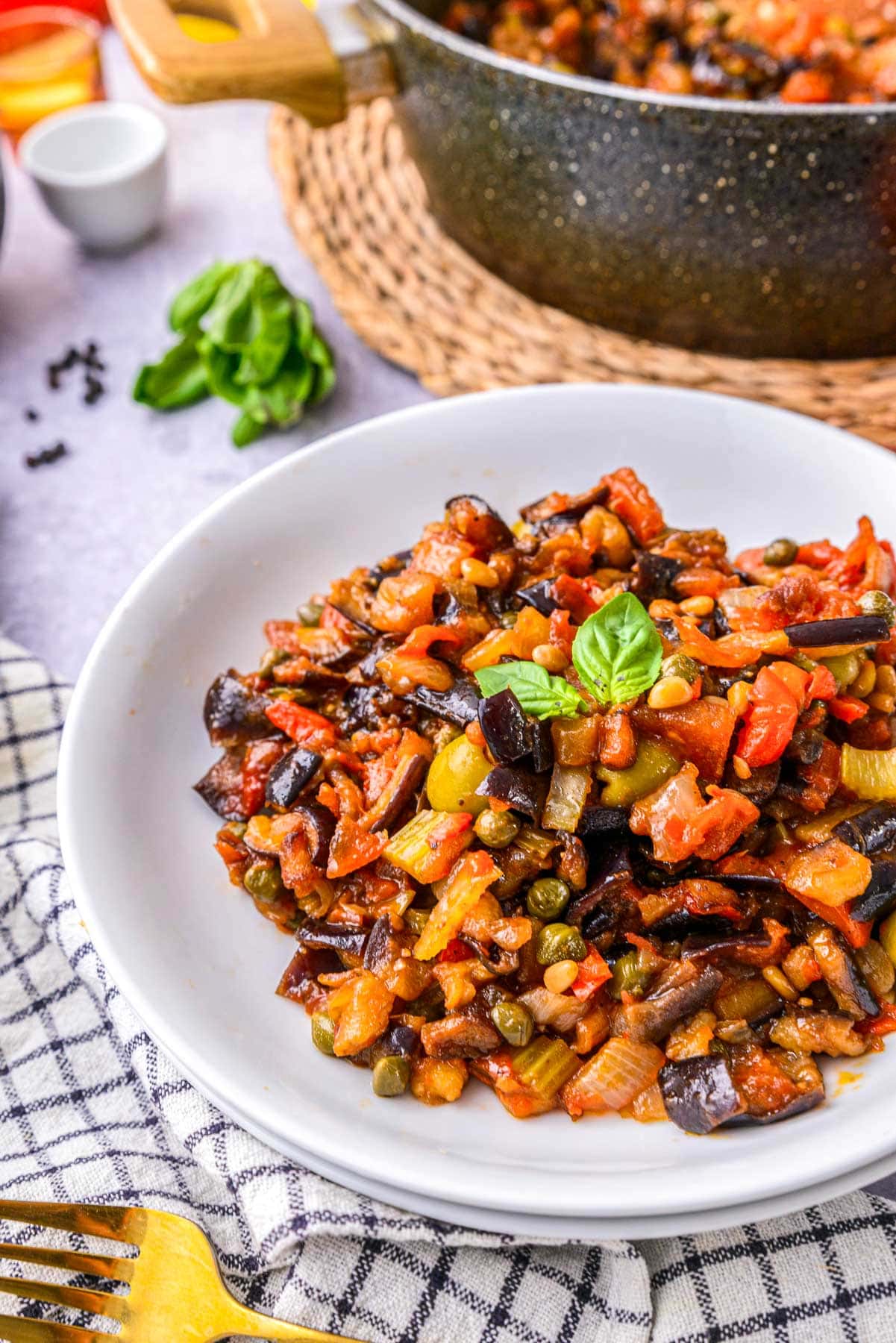 italian caponata stew dish in bowl on counter with dishes around.