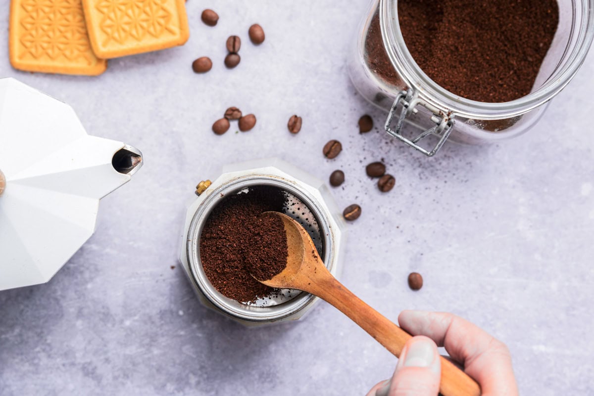 scooping grounds for espresso on counter.