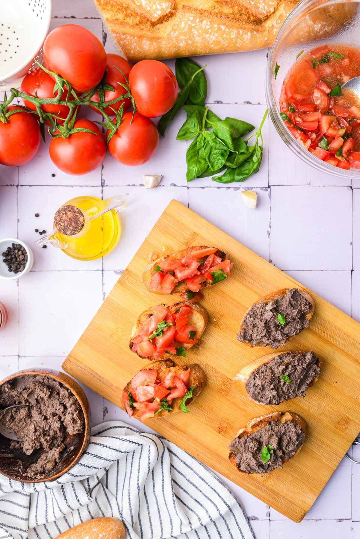 chicken liver bruschetta and tomato bruschetta on wooden board on counter.
