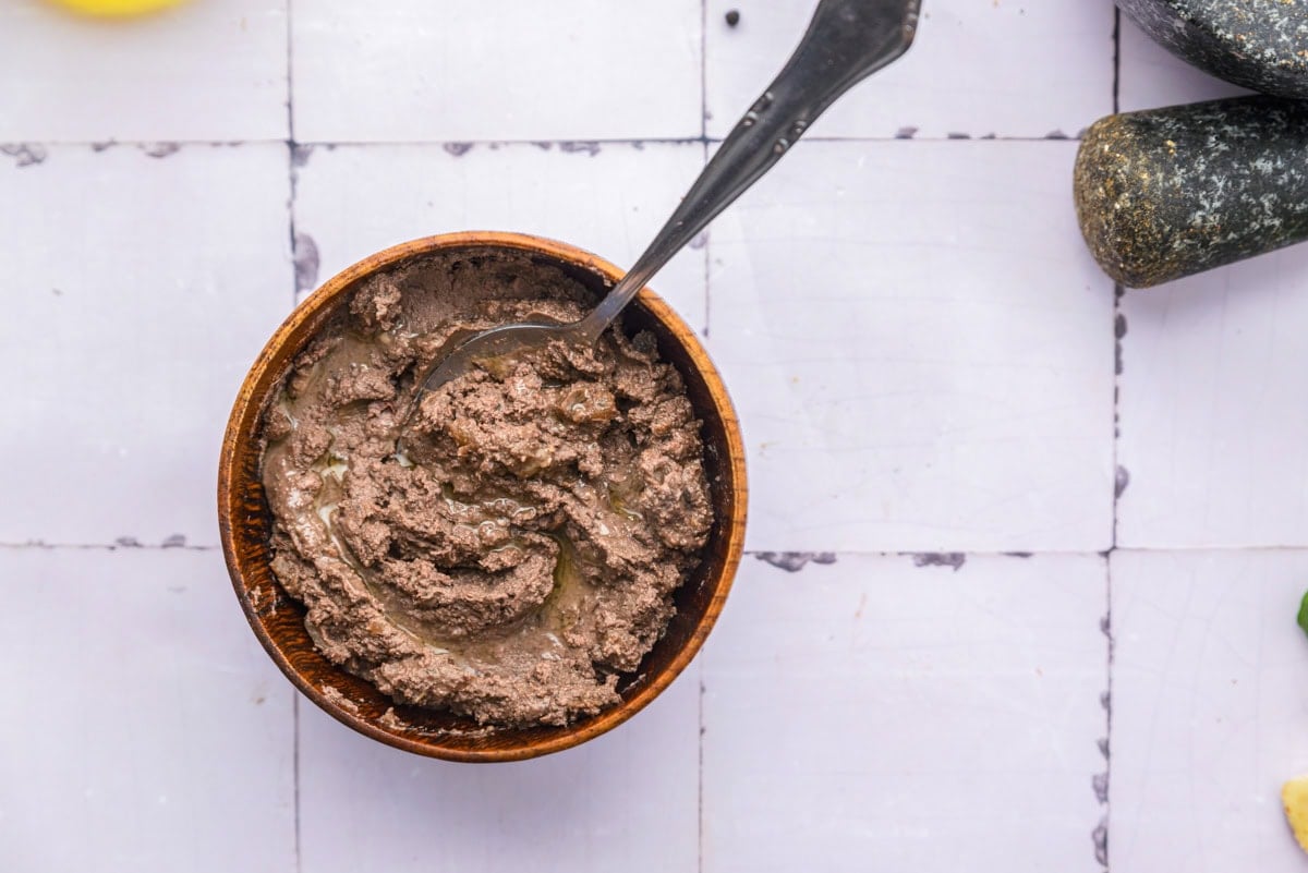 chicken liver paste in bowl with spoon sitting on counter.