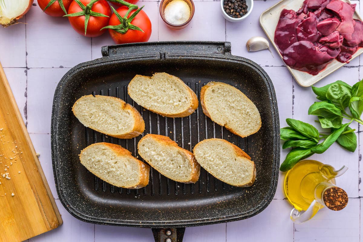 slices of crusty bread being grilled in pan.