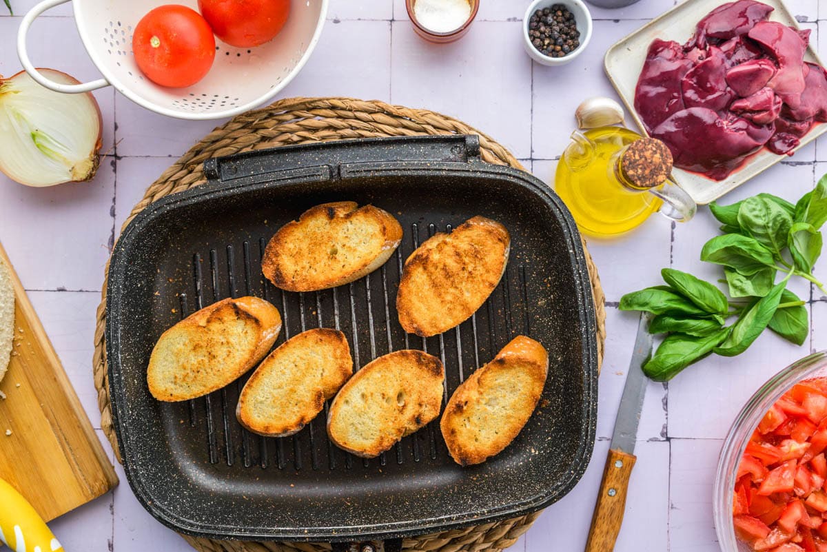 grilled bread in pan on counter with ingredients around.